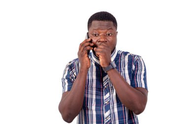 Ağzını kapatırken cep telefonuyla konuşan yakışıklı bir gencin portresi..