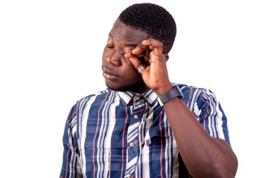 Ayakta duran ve gözlerini ovuşturan yakışıklı bir gencin portresi. beyaz arkaplanda izole.