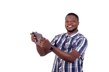 Gülümserken dijital tablet kullanan yakışıklı bir gencin portresi..