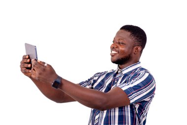 Dijital tablette gülümserken fotoğraf çeken yakışıklı bir gencin portresi..