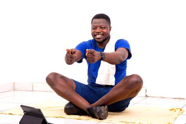 Dijital tablete bakıp gülümseyen genç bir sporcunun portresi..