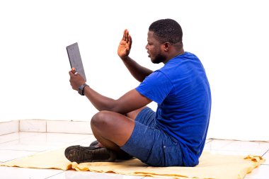 Dijital tabletinde gülümserken elini sallayan yakışıklı bir genç adamın portresi..