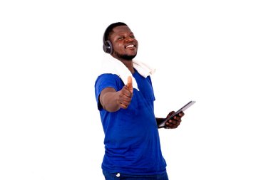 Dijital tablet kullanarak kulaklıkla müzik dinleyen ve gülümseyen yakışıklı bir gencin portresi..