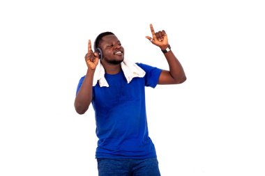 Yakışıklı, genç bir adamın portresi kulaklıkla müzik dinlerken boynunda havluyla gülümsüyor..