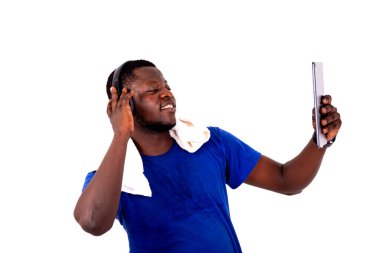 Yakışıklı bir genç adamın portresi kulaklıkla müzik dinleyen ve dijital tabletle fotoğraf çeken ve gülümseyen..