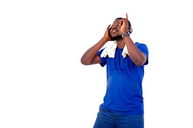 Yakışıklı, genç bir adamın portresi kulaklıkla müzik dinlerken boynunda havluyla gülümsüyor..