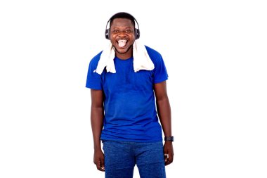 Yakışıklı, genç bir adamın portresi kulaklıkla müzik dinlerken boynunda havluyla gülümsüyor..