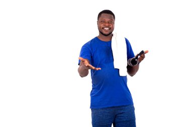 Spor kıyafetli genç adam, beyaz arka planda, kulaklıklı, gülümseyerek dışarı çıkıyor..