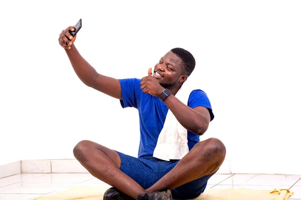 Yakışıklı Bir Genç Adamın Portresi Yerde Oturuyor Cep Telefonundaki Bir — Stok fotoğraf