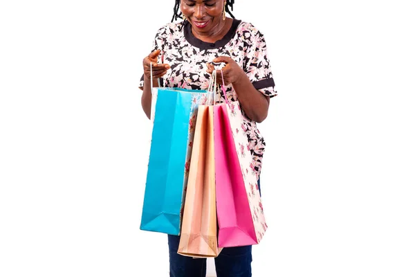 一个漂亮的成熟女人笑着看着购物袋的画像 — 图库照片