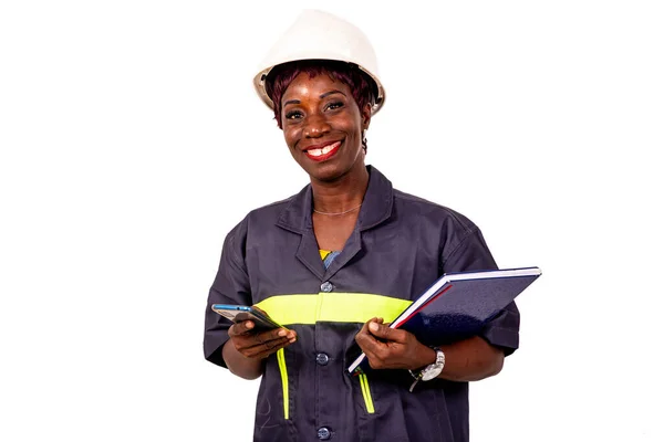 携帯電話やノートを持ちながら笑顔で作業服を着た美しい女性技術者の肖像画 — ストック写真