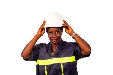 Güzel bir kadın mühendisin portresi iş üniforması ve beyaz güvenlik kaskı giyiyor..