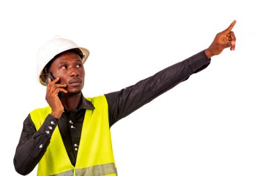 Girişimci beyaz arka planda duruyor cep telefonuyla konuşuyor ve parmakla işaret ediyor..