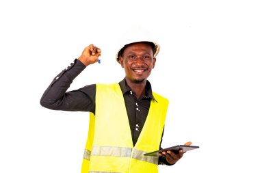 Beyaz arka planda güvenlik kaskı olan bir inşaat mühendisi elinde tablet ve kalemle kameraya bakıp gülümsüyor..