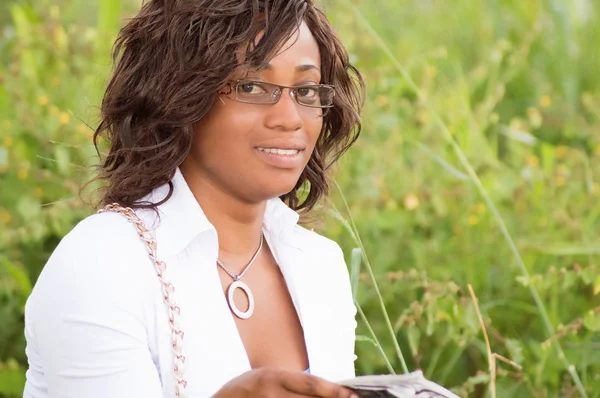 Smiling young woman holding a magazine. — Stock Photo, Image