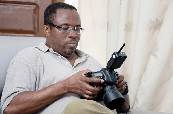Fotógrafo africano olhando para a tela de sua câmera digital . — Fotografia de Stock