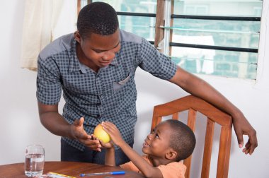 Çocuk babasına bir elma gösterilen.