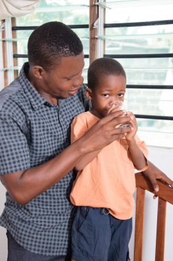 Baba çocuğunu su verir.