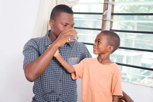 Kind kijken naar zijn vader drinkwater — Stockfoto