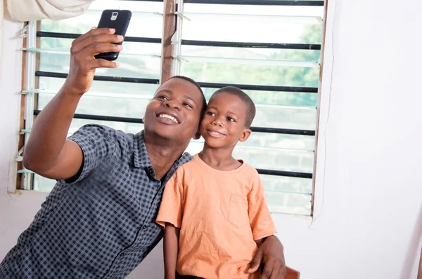 Vader en zoon nemen van foto's met zijn telefoon. — Stockfoto