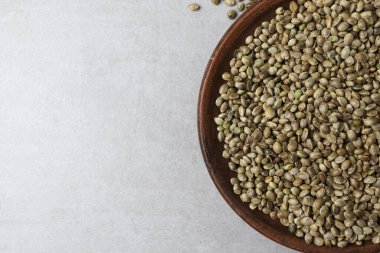 Beton yüzeyinde kenevir tohumlarıyla dolu bir kase var.. 