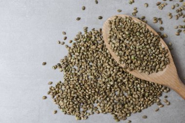 Beton yüzeyinde kenevir tohumları olan tahta kaşık. Yemek arkaplanı. Yatay yönelim.