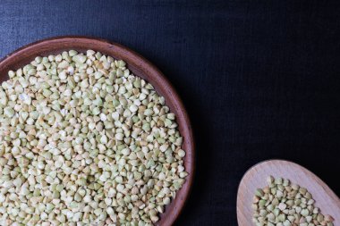 Siyah arka planda kil bir fincanda yeşil karabuğday. Gıda arkaplanı.