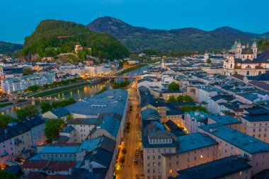 Avusturya 'nın eski Salzburg kasabasına bakan Hohensalzburg kalesinin günbatımı manzarası.
