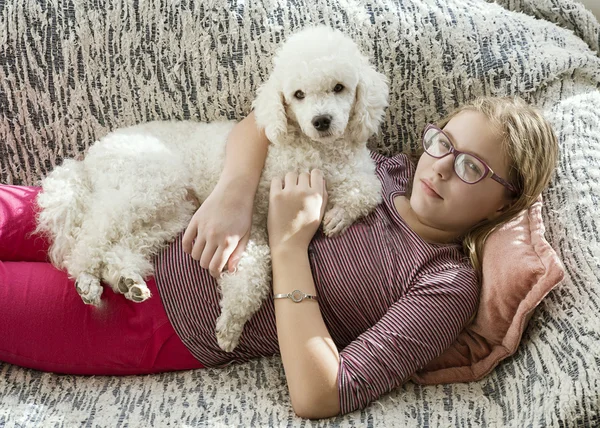 Chica con un perro en la cama —  Fotos de Stock