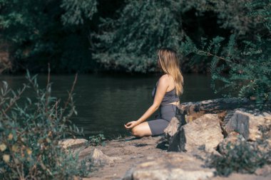 Nehir kenarında yoga yapan bir kız.