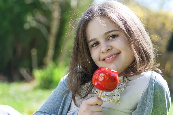 Flicka med karamell äpple — Stockfoto