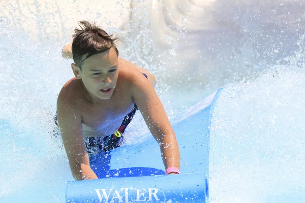 :Jonge jongen op de mat racer Slide — Stockfoto