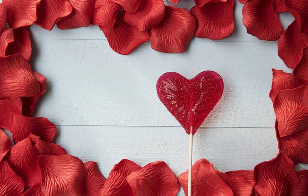 Lízátko srdce a nádherné okvětní lístek růže — Stock fotografie