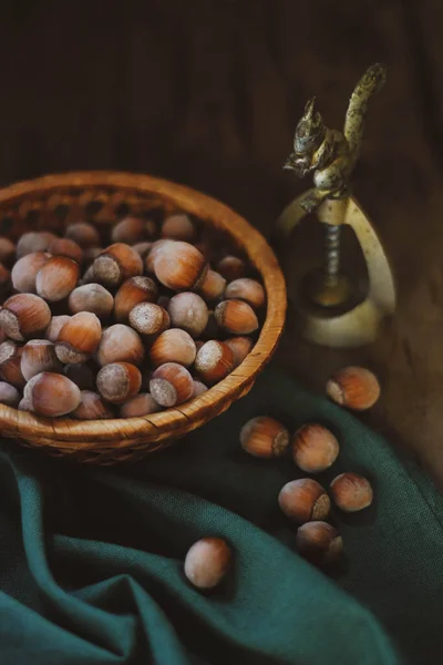 Yeşil kumaş üzerinde fındık ve fındık kıracağı sepeti 