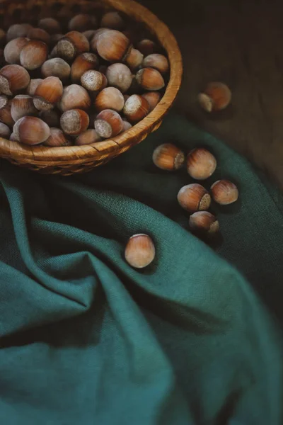 Yeşil kumaş üzerinde bir sepet fındık