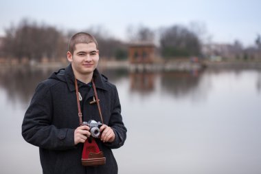 Vintage kamera tutan genç fotoğrafçı