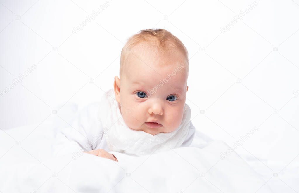 Portrait of a charming baby girl in a white bed
