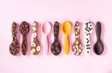 Pembe zemin üzerinde renkli kurdeleler ve aksesuarlarla farklı düz yatıyordu..