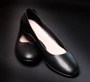 Siyah arka planda kadın siyah deri bale ayakkabıları.