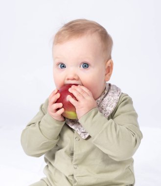 Güzel bebek bir elma tutuyor, beyaz bir arka plan.
