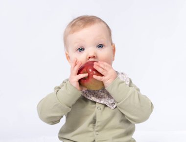 Güzel bebek bir elma tutuyor, beyaz bir arka plan.