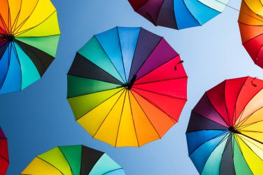 Mavi arka planda gökkuşağı şemsiyeleri