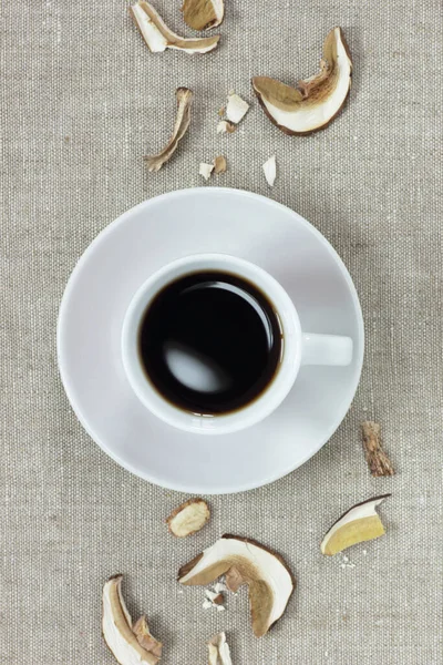 Mushroom powdered coffee from above flat on linen textile background texture with dry mushrooms, closeup, vertical, copy space, superfood and healthy food and drink concept