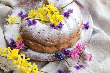 Bahar tatili pastası. Bahar çiçekleri, yakın plan, fotokopi alanı, yumurtasız vejetaryen pişirme ve paskalya bayramı tatlı konseptiyle süslenmiş.