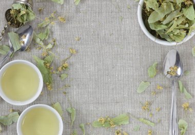 Yukardan gelen kurumuş kireç çiçekleri keten tekstil kireç yapraklı tomurcuklar temiz ve fincanlar çay ile, üstten görüş, düz yatış, yakın çekim, kopyalama alanı, bitkisel çay nad naturopati konsepti