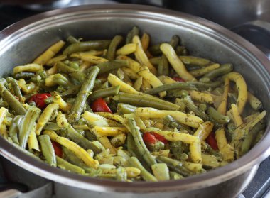 Çelik tavada pişirilmiş yeşil fasulye, domates ve bezelye, protein vegan yemeği pişirme süreci, yakın çekim, fotokopi alanı, vejetaryen gıda konsepti.