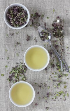 Kekik kurutulmuş çiçek çayı keten tekstil bardaklarında, yakınlarda çiçekler ve kaşık, yakın plan, kopyalama alanı, düzlük, yukarıdan bakıldığında, sağlıklı bitkisel çaylar ve doğal destek konsepti.