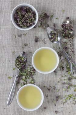 Kekik kurutulmuş çiçek çayı keten tekstil bardaklarında, yakınlarda çiçekler ve kaşık, yakın plan, kopyalama alanı, düzlük, yukarıdan bakıldığında, sağlıklı bitkisel çaylar ve doğal destek konsepti.