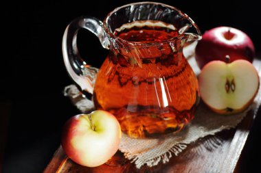 Elma sirkesi, koyu siyah arka planda cam bir sürahide elma suyu içmek, yakın plan, fotokopi alanı, doğal kozmetik ürünlerinde sağlıklı içecek, daha temiz ve vücut bakımı için