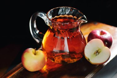 Elma sirkesi, koyu siyah arka planda cam bir sürahide elma suyu içmek, yakın plan, fotokopi alanı, doğal kozmetik ürünlerinde sağlıklı içecek, daha temiz ve vücut bakımı için